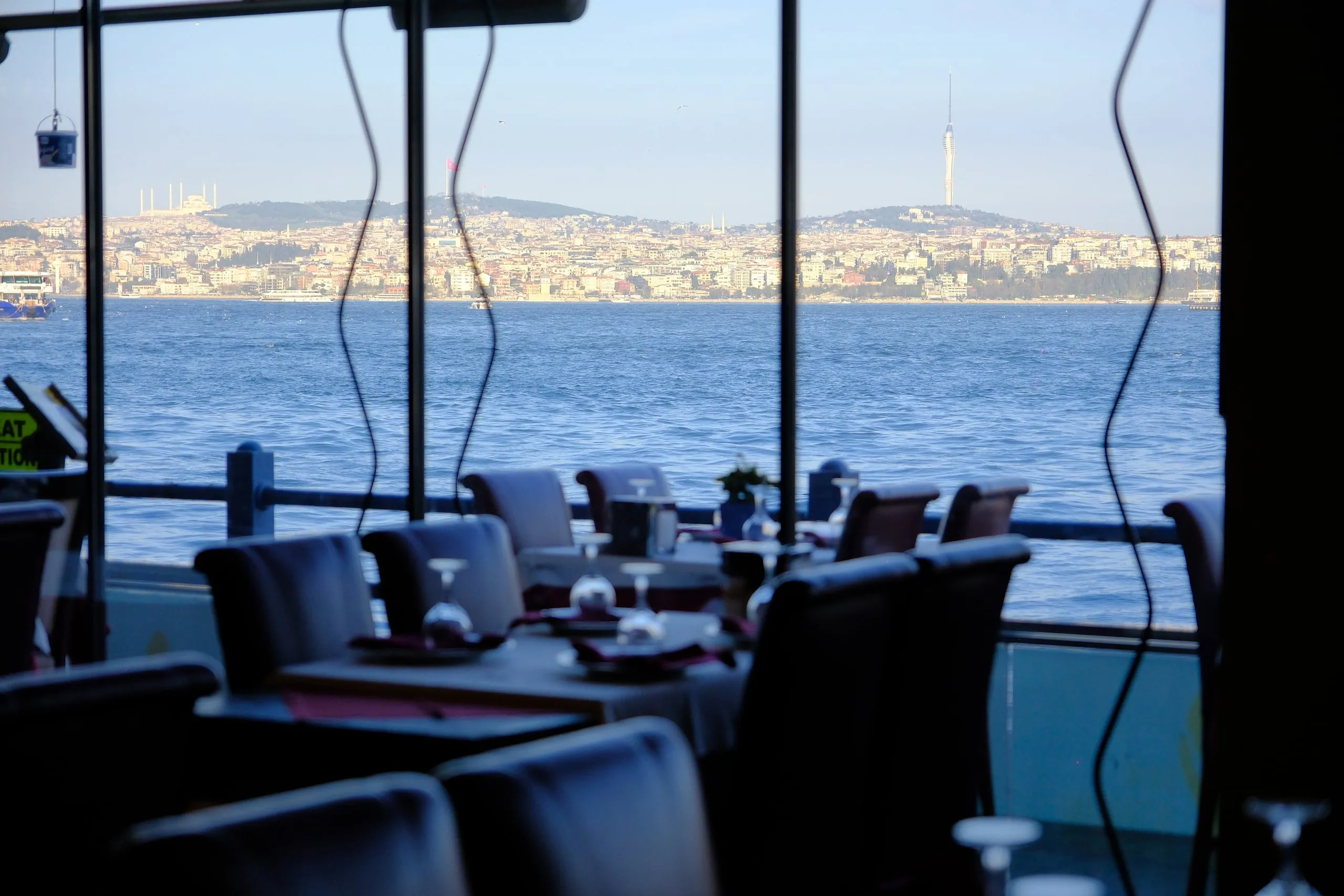 Daytime view of the Bosphorus through the restaurant windows, with Üsküdar and Çamlıca across the water