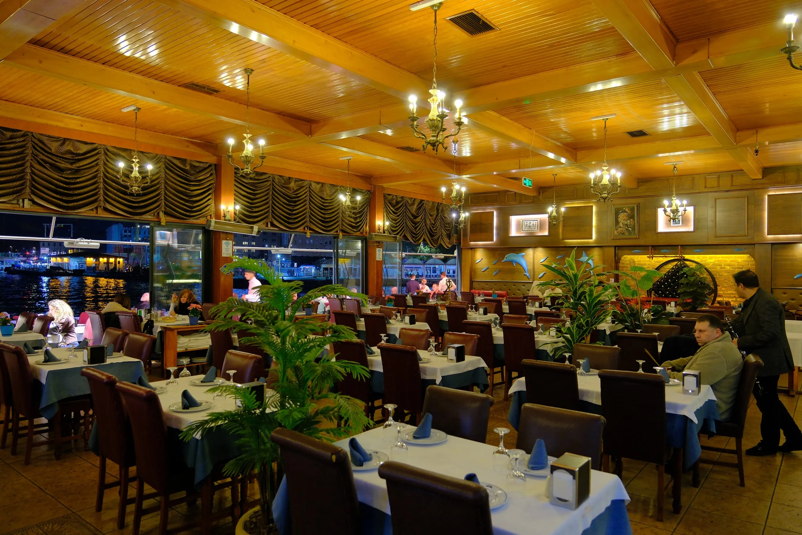 Indoor dining room with a wooden ceiling and chandeliers