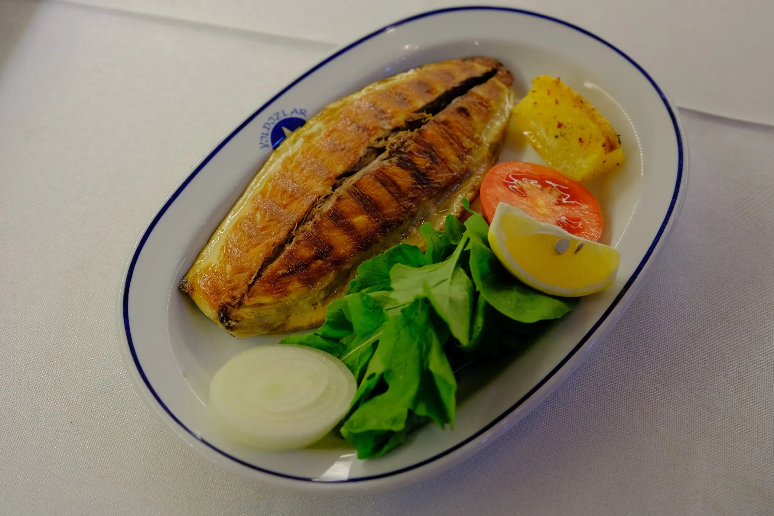 Grilled fish served with arugula and lemon